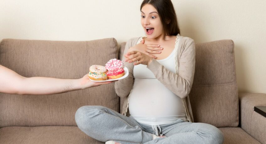 donna incinta che mangia dolci