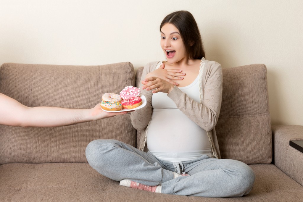 donna incinta che mangia dolci